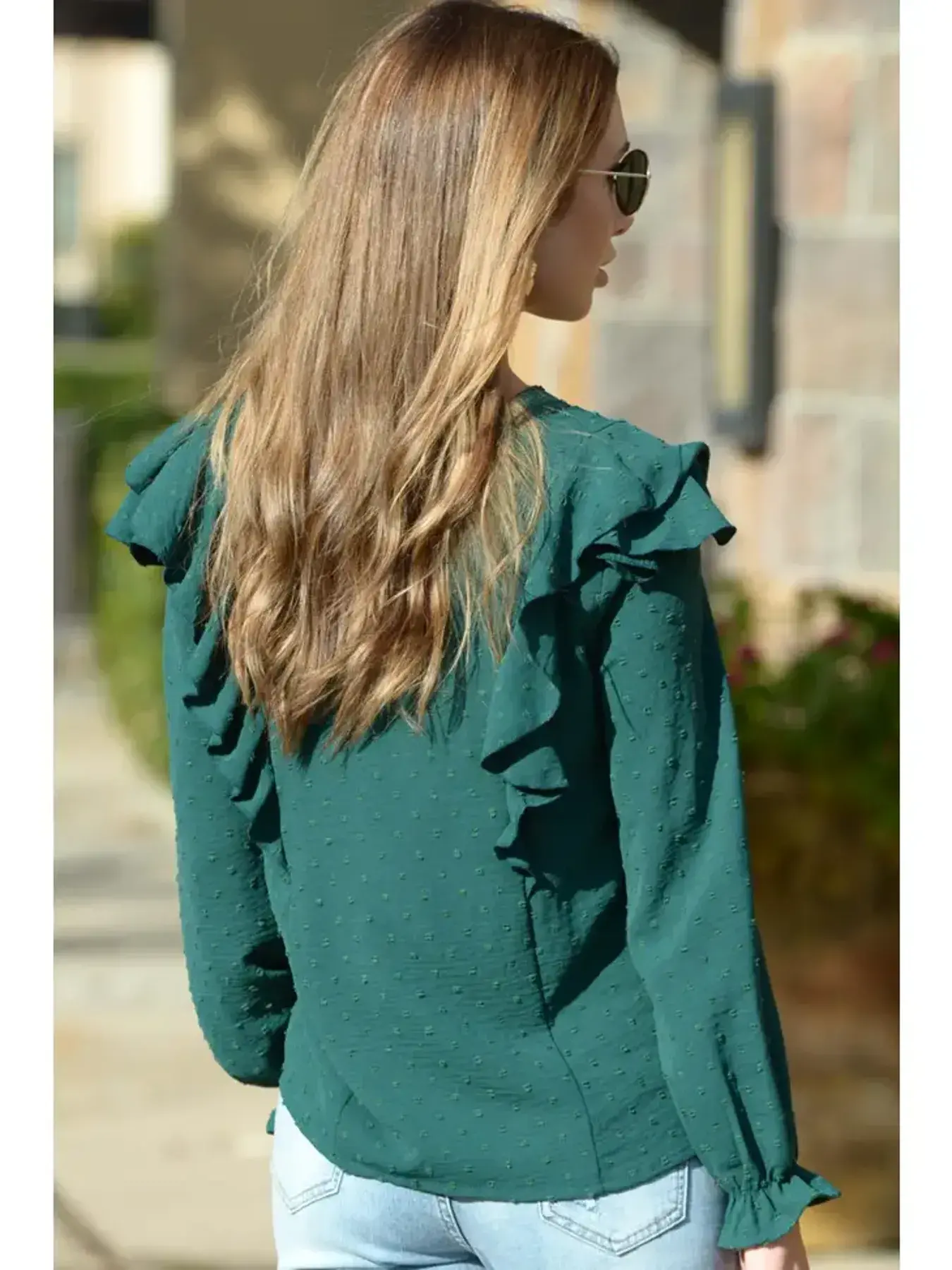 Mujer Vistiendo una blusa de mangas larga con encajes en color verde de la firma de moda Tierra de Tartessos,.